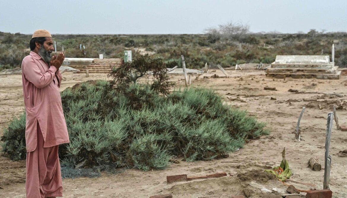 Habibullah Khatti, a local resident, prays at his mothers grave before abandoning Abdullah Mirbahar village in Kharo Chan town, in the Indus delta on June 25, 2025. — AFP