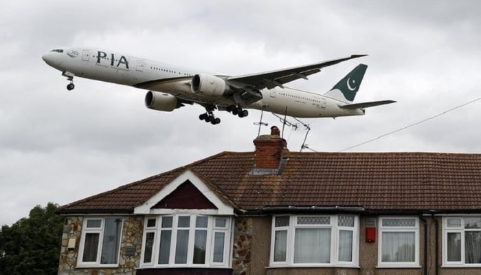 After five years, PIA resumes UK flights as fake pilot A Pakistan International Airlines (PIA) Boeing 777 comes in over houses to land at Heathrow Airport in west London on June 8, 2020.—AFP
