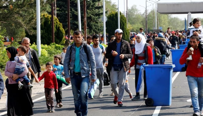 Austria deports first Afghan since Taliban seized power, says more Migrants pass by garbage bins as they walk towards the Austrian border from Hegyeshalom, Hungary. — Reuters