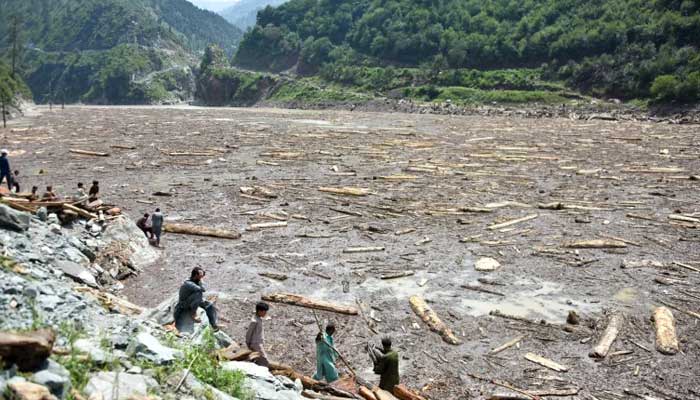 ‘Bureaucratic gridlock undermining’ Pakistan’s climate fight Locals collect wood from Noseri Dam near Muzaffarabad after flash floods. — AFP/File