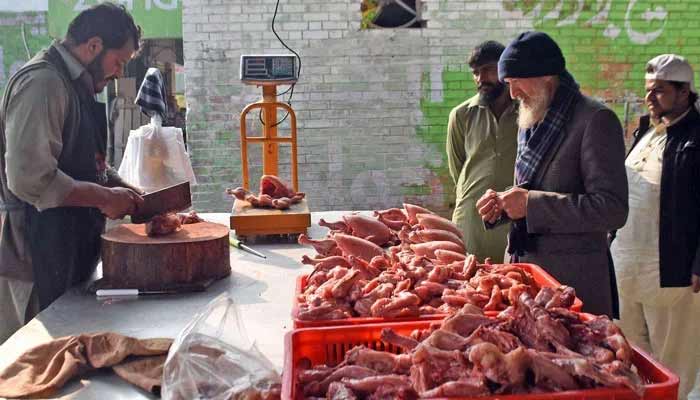 ‘Dead chicken meat’ seized in Karachi Photo shows chicken seller cutting the chicken.— Photo/File