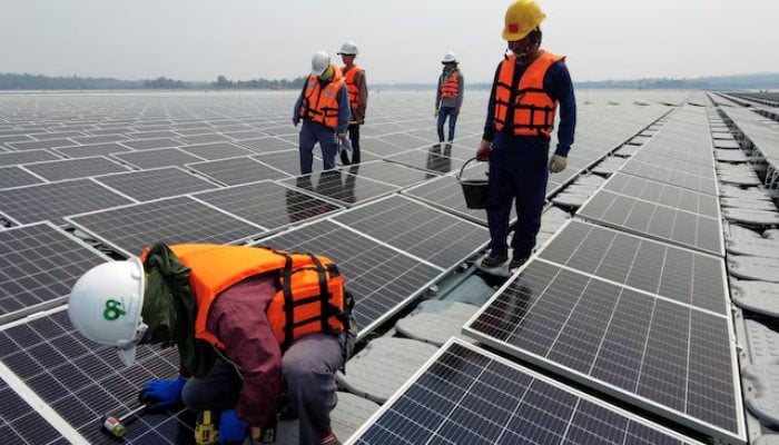 Govt weighs slashing solar net metering buyback rate by over A worker kneels by one of the solar cell panels over the water surface of Sirindhorn Dam in Ubon Ratchathani, Thailand, April 8, 2021.— Reuters