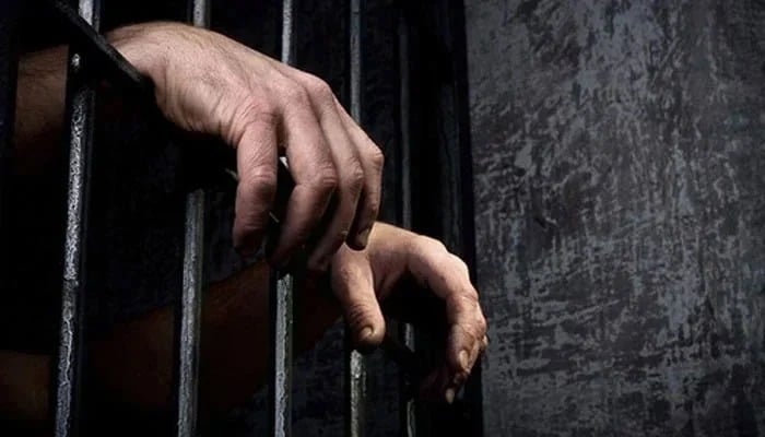 House help living ‘a millionaire’s life’ arrested in Karachi for This representational image shows the hands of an incarcerated person. — AFP/File