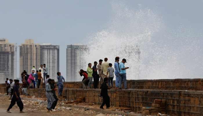 Karachi’s temperature could rise in upcoming days People gather near the rising waves at Clifton Beach, in Karachi, on June 13, 2023. — Reuters