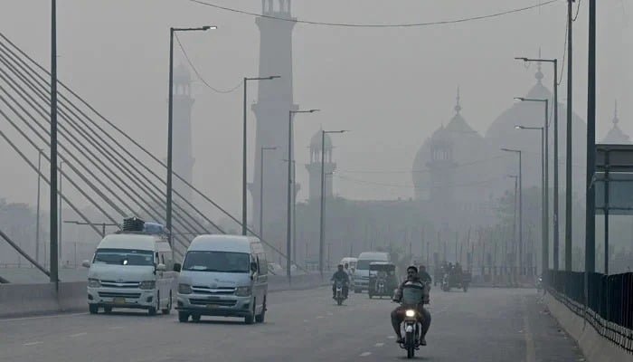 Lahore tops global pollution index as smog season begins Commuters drive along a road amid heavy smog in Lahore on October 29, 2024. — AFP