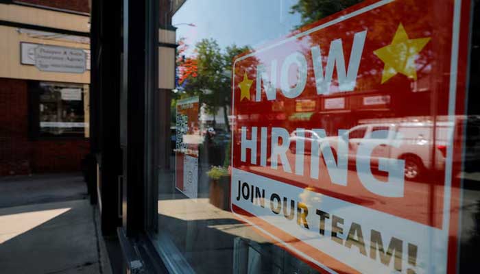 A Now Hiring sign hangs in the window of a hair salon in the Greater Boston town of Medford, Massachusetts, US on August 12, 2025. — Reuters