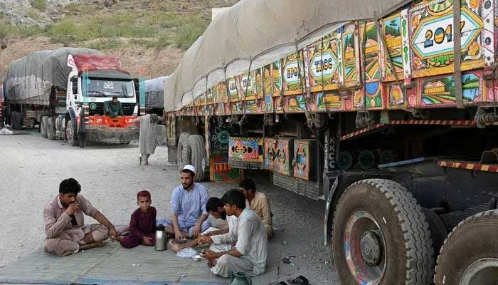 Pakistan implements revised barter trade mechanism with Iran, Russia, and Drivers along with a boy drink tea next to trucks parked along a road near the Pakistan-Afghanistan border in Torkham. — AFP/File