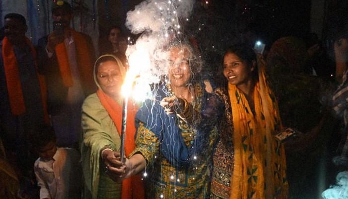 President, PM emphasise unity and interfaith harmony on Diwali Hindu women play with a sparkler amid Diwali celebrations in this undated image. — AFP
