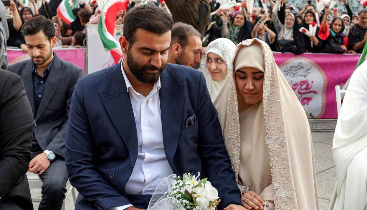A bride and groom couple attends a public mass wedding ceremony at Imam Hossein Square in Tehran on May 18, 2026.— AFP